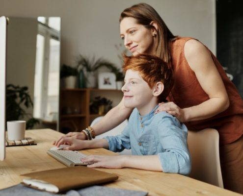 a parent helping their child learn at home online during the pandemic