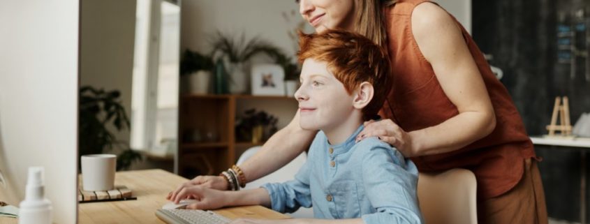 a parent helping their child learn at home online during the pandemic