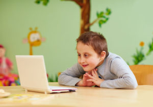 a boy with Asperger's syndrome at home doing online speech therapy