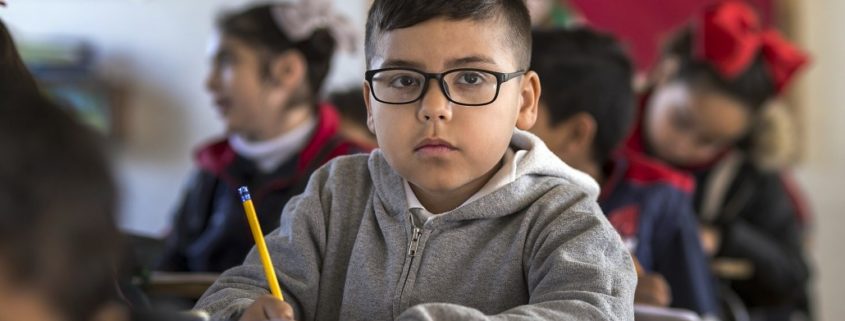 a child with a speech disorder at his desk at school