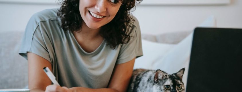 a woman with pen and paper researching lisp disorders while smiling