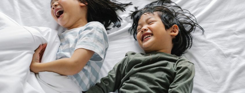 A boy and girl at home laughing and speaking to each other