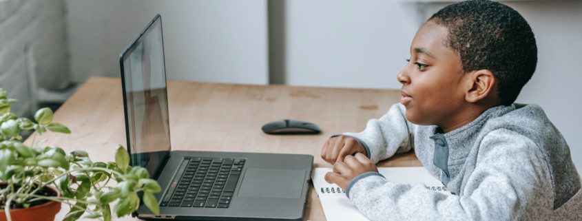 a 5 year old child at a laptop learning at home