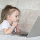 A child at home on a laptop doing articulation therapy from home