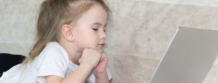 A child at home on a laptop doing articulation therapy from home