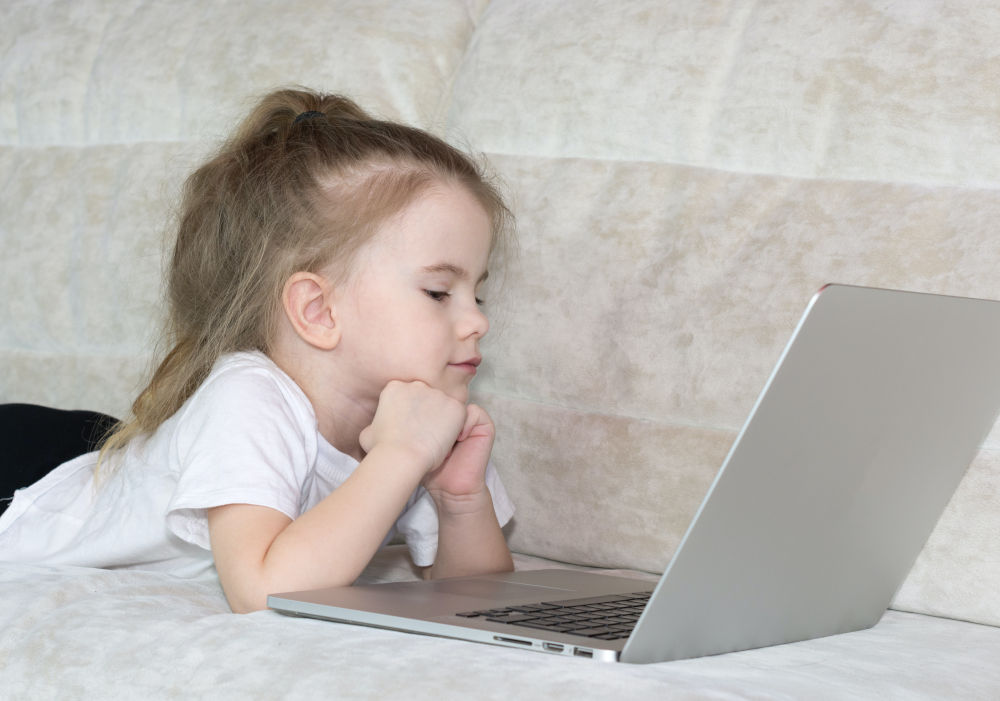 A child at home on a laptop doing articulation therapy from home