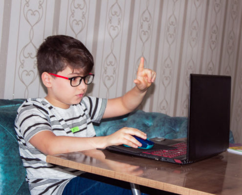 a child at home doing online speech therapy