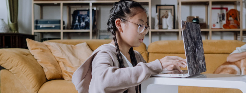 a girls at home working on her speech via a laptop