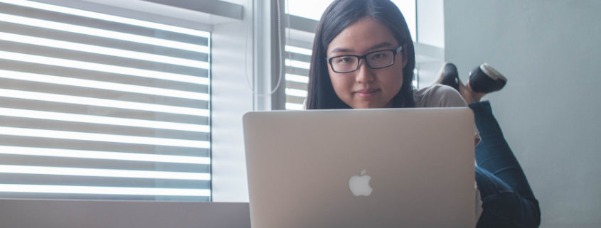 a woman at home on her laptop doing voice therapy