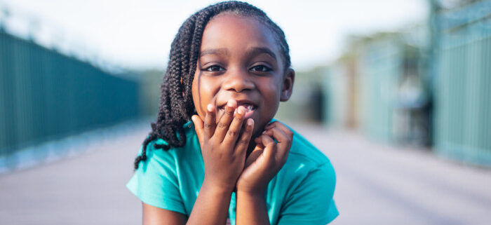 a child looking at the camera who has suffered hearing loss