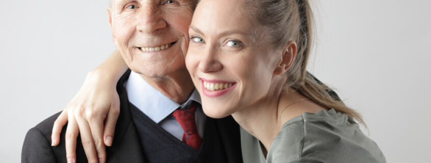 a woman with her arm over an elderly man