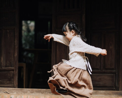 a child in traditional dress dancing and looking happy