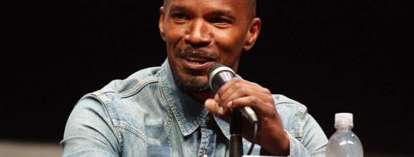 jamie foxx on a microphone speaking to an audience