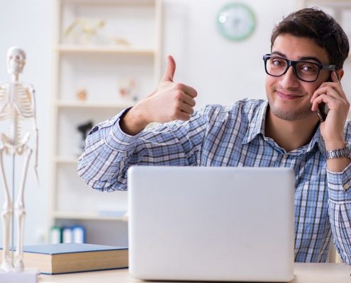 man with his thumbs up on a laptop