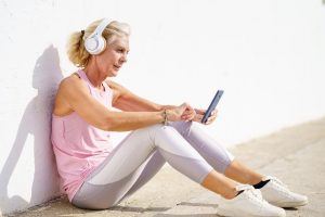 woman in workout gear on her phone learning remotely