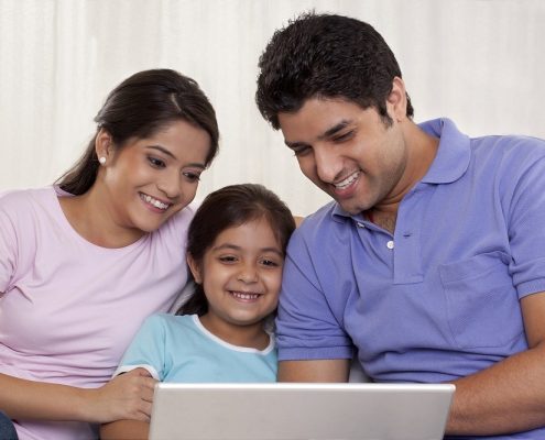 parents with their child on a laptop at home