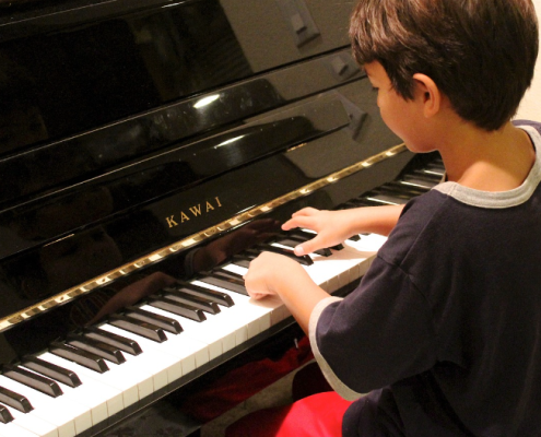 a boy playing a piano to aid his speech therapy