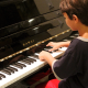a boy playing a piano to aid his speech therapy