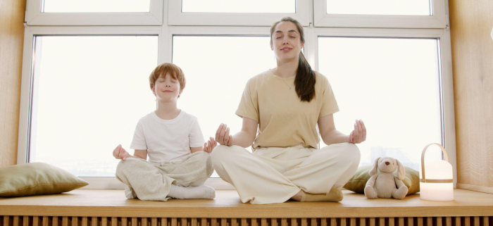 two people meditating on a wooden surface
