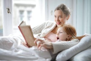 A woman reading a book to her child