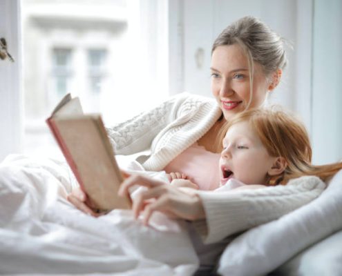 A woman reading a book to her child